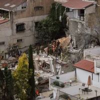 Israel building collapse emergency response teams searching through debris