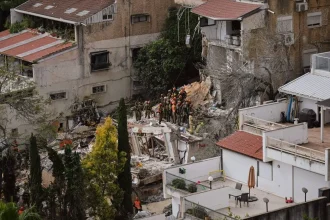 Israel building collapse emergency response teams searching through debris