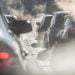 Blurred silhouettes of cars surrounded by steam from the exhaust pipes. Traffic jam
