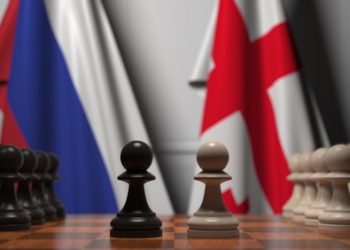 Flags of russia and georgia behind pawns on the chessboard. chess game or political rivalry