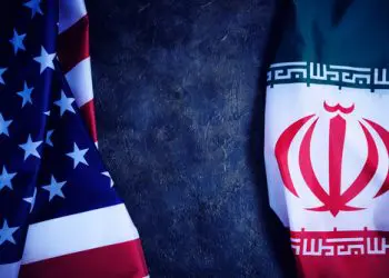 Flags of Iran and United States of America are opposite each other dark background