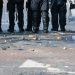 Belfast, UK, 12 July 2012 - Stones and bricks litter the road as police riot squad move forward to force a crowd of youths to retreat.