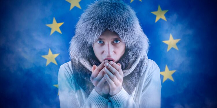 Increase in the price of natural gas for home heating. Transition to renewable energy sources. Energy crisis in Europe. A citizen of Europe freezes in front of the flag.