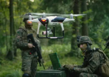 In the Military Staging Base Army Engineer and Soldiers Fly Military Grade Industrial Drone for their Reconnaisance/ Surveillance Mission/ Operation. Theater of Operation is in Forest Area.