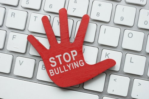 Red palm on the keyboard with the inscription stop bullying. Cyberbullying concept.