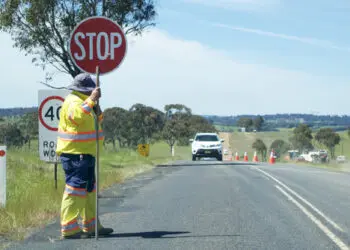 Road Stop sign being held by a worker on a country road