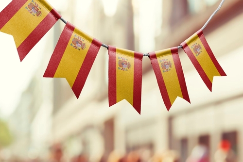 A garland of Spain national flags on an abstract blurred background.