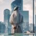 Successful Muslim Businessman in Traditional White Kandura Standing in His Modern Office Looking out of the Window on Big City with Skyscrapers. Successful Saudi, Emirati, Arab Businessman Concept.