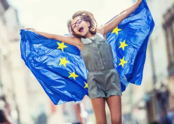 Cute happy young girl with the flag of the European Union.