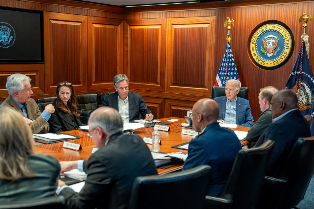 Diplomats discussing the evolving US Iran conflict strategy during international negotiations