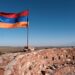 Armenian flag on Dashtadem Fortress in front of Mount Ararat on sunny summer day. Dashtadem, Aragatsotn Province, Armenia.