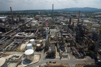 Eni CEO oil market outlook featuring a modern energy refinery supporting global oil production