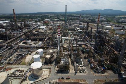 Eni CEO oil market outlook featuring a modern energy refinery supporting global oil production