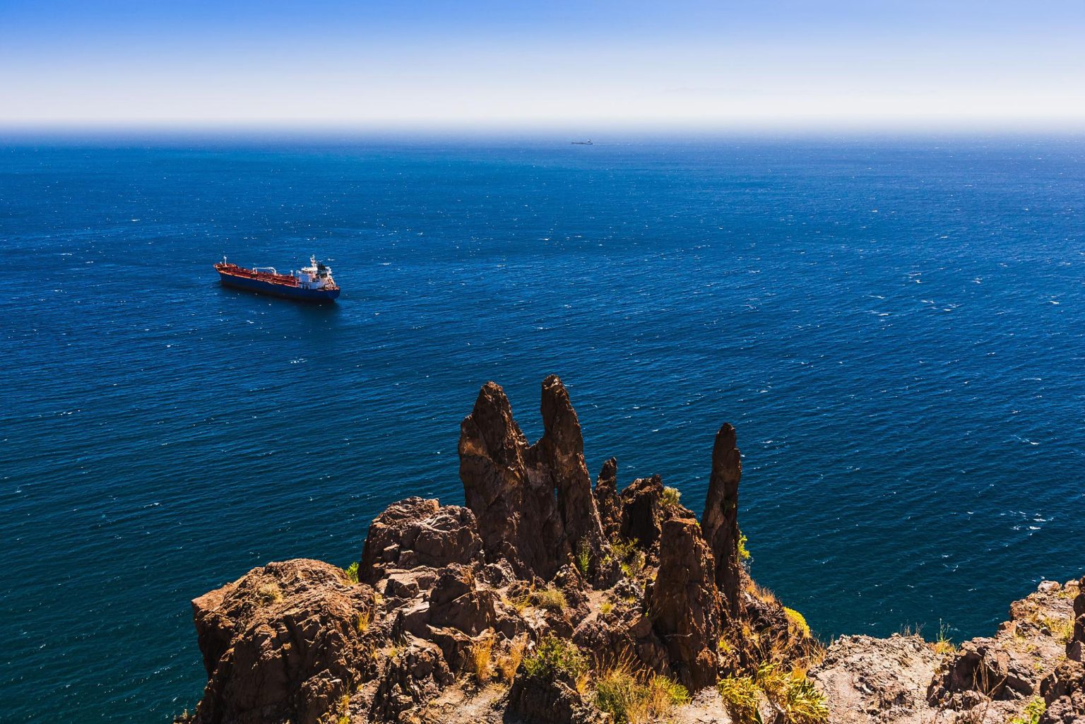 global oil shipping risks with oil tanker moving through narrow maritime route