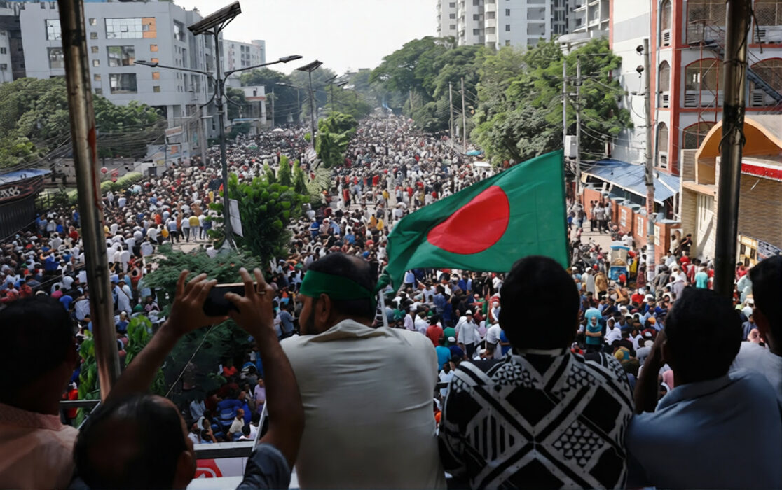 Bangladeshi protesters waving a national flag during street demonstrations, reflecting public anger and unrest after activist’s death