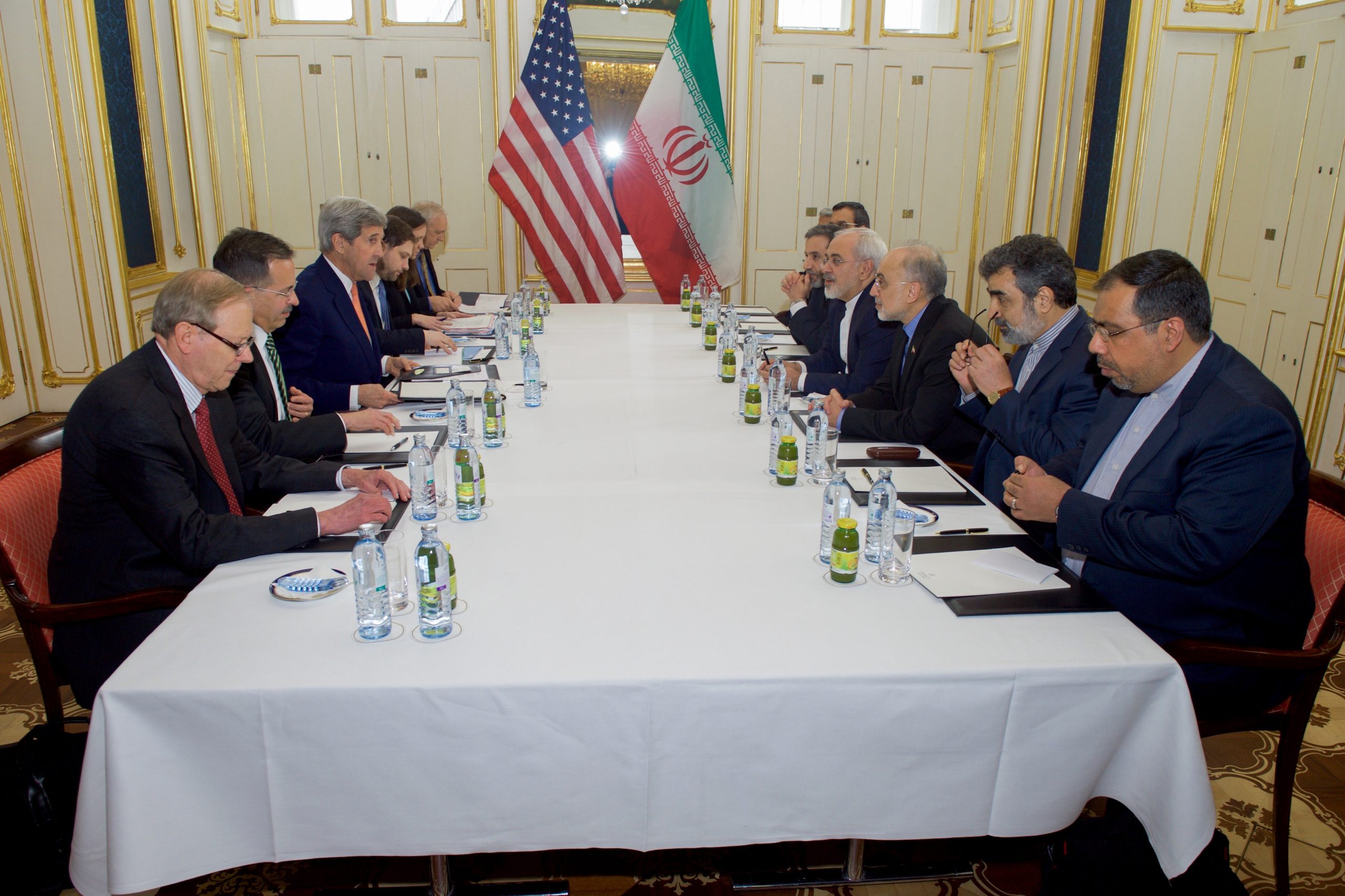 Iran US negotiations diplomatic tensions US Iran flags meeting
