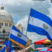 San Salvador, El Salvador - September 15th, 2021: Protesters hold national flags and march near the cathedral against the politics of current president Nayib Bukele.