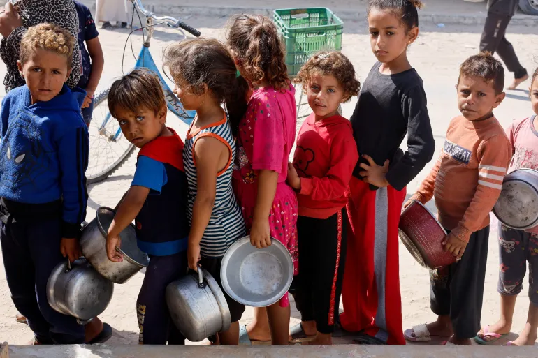 Palestinian children queue to receive food