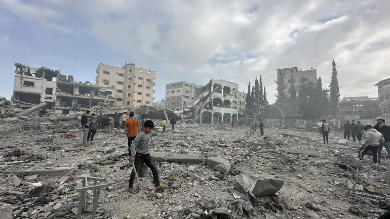 Palestinians inspect the area after an Israeli attack on Gaza City