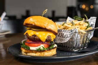 Gourmet cheeseburger representing the New York-inspired dining concept of Manhattn’s Burgers.