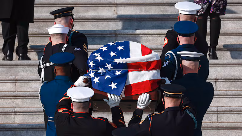Flag draped coffin during military ceremony