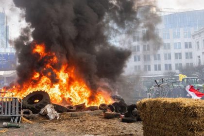 Brussels police clashes coverage illustrated by smoke rising during an earlier protest outside the European Parliament.