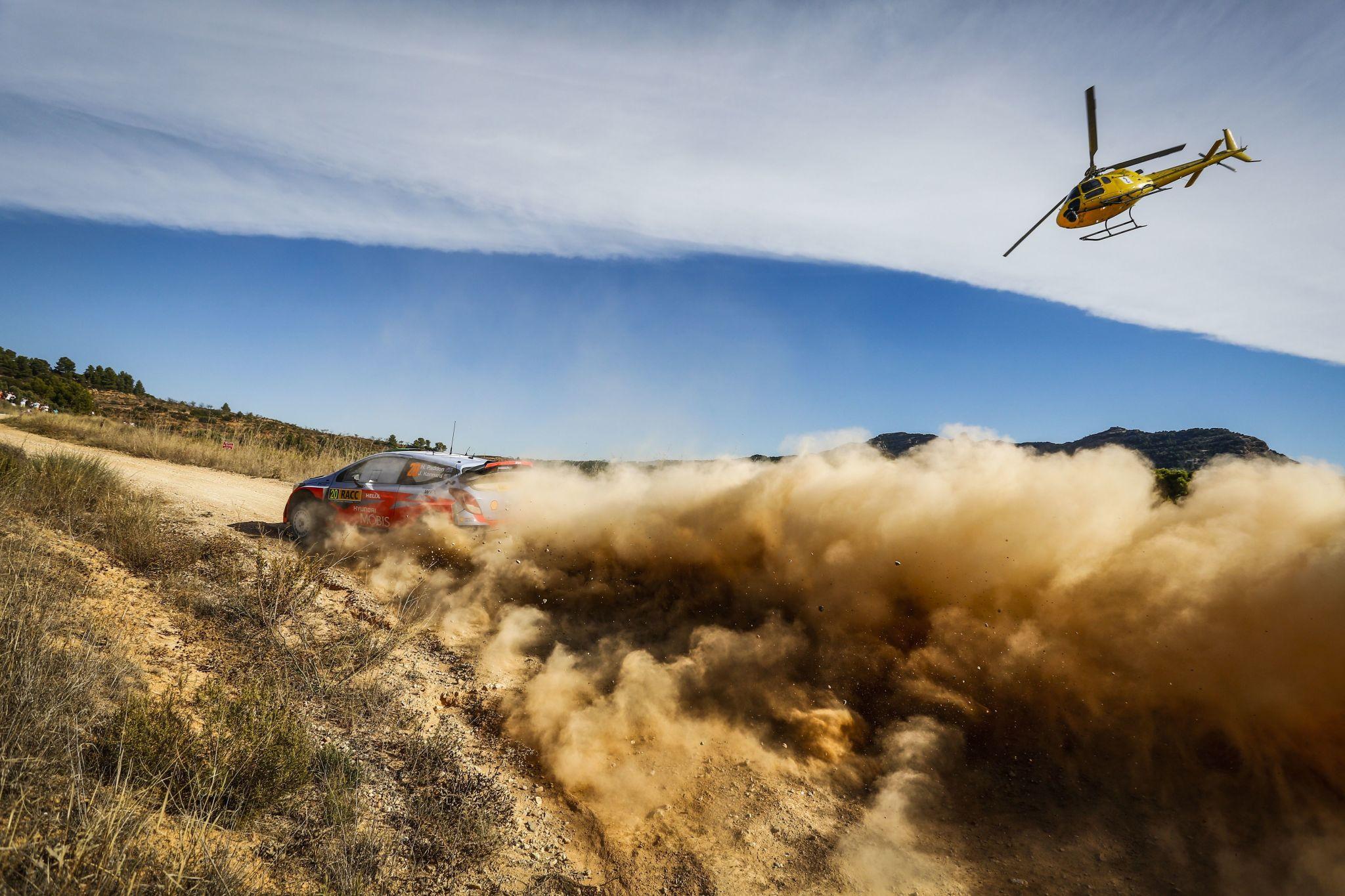 global sports investment news world rally championship car speeding through mountain terrain