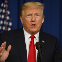 Close up portrait of Donald Trump with a serious expression during a press appearance.