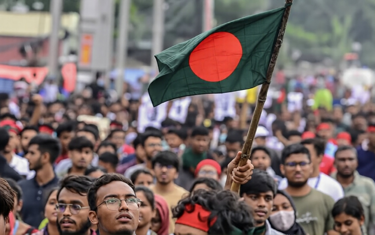Bangladeshi demonstrators holding signs and banners during a protest, showing grassroots participation in the unrest