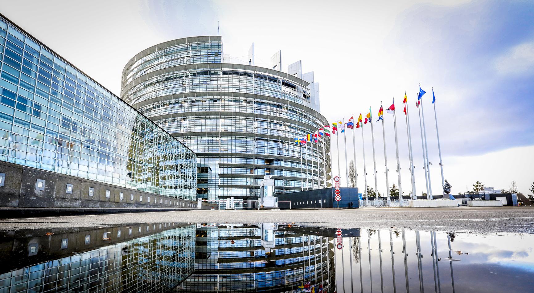 European Parliament building in Strasbourg with European Union flags.