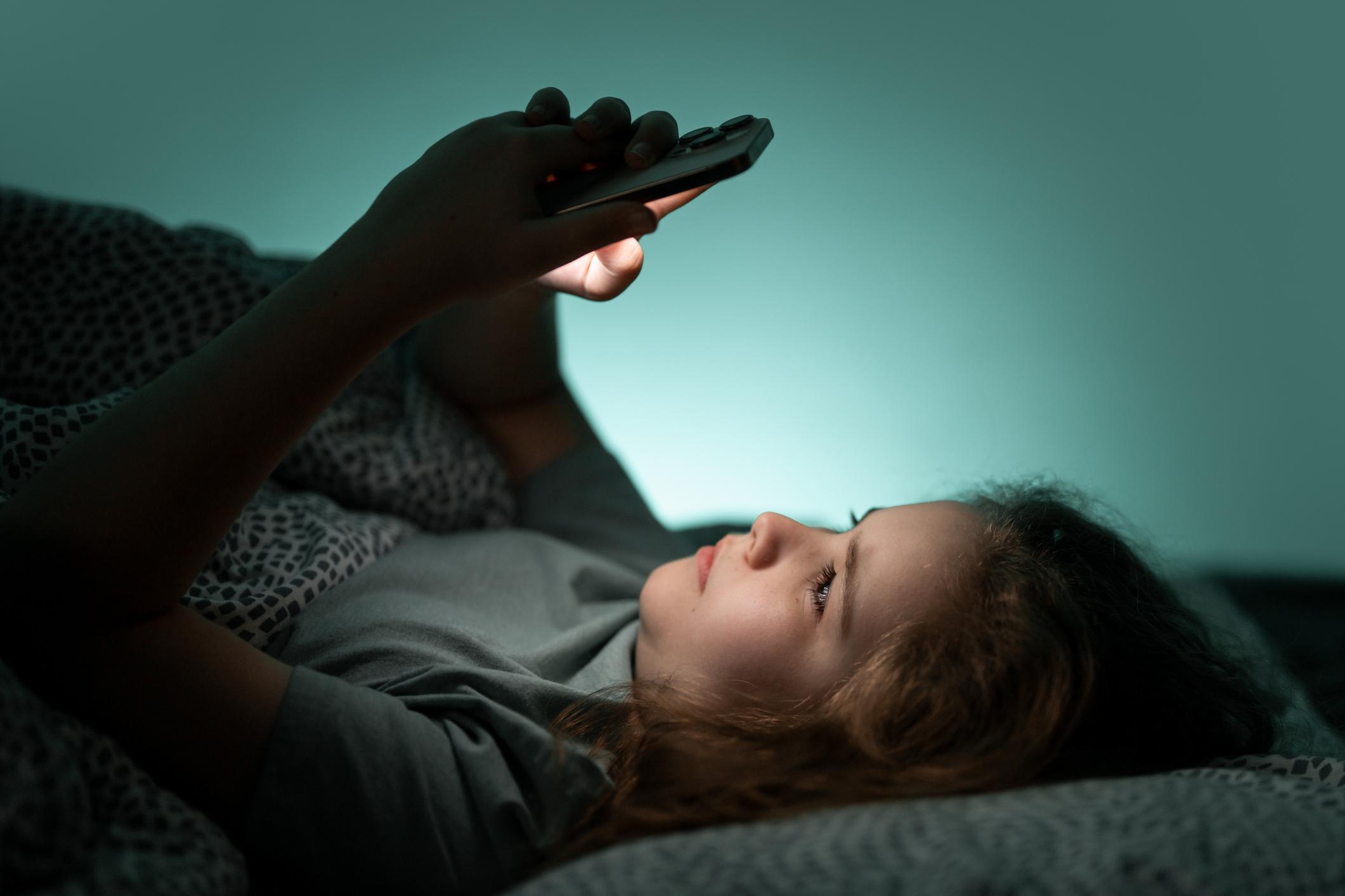Teenager using smartphone as UK social media ban discussion expands