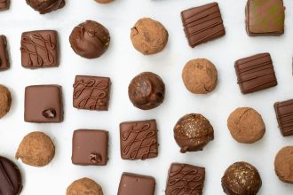 Artisan chocolatier preparing Belgian pralines by hand, illustrating the craft behind Leonidas chocolates.