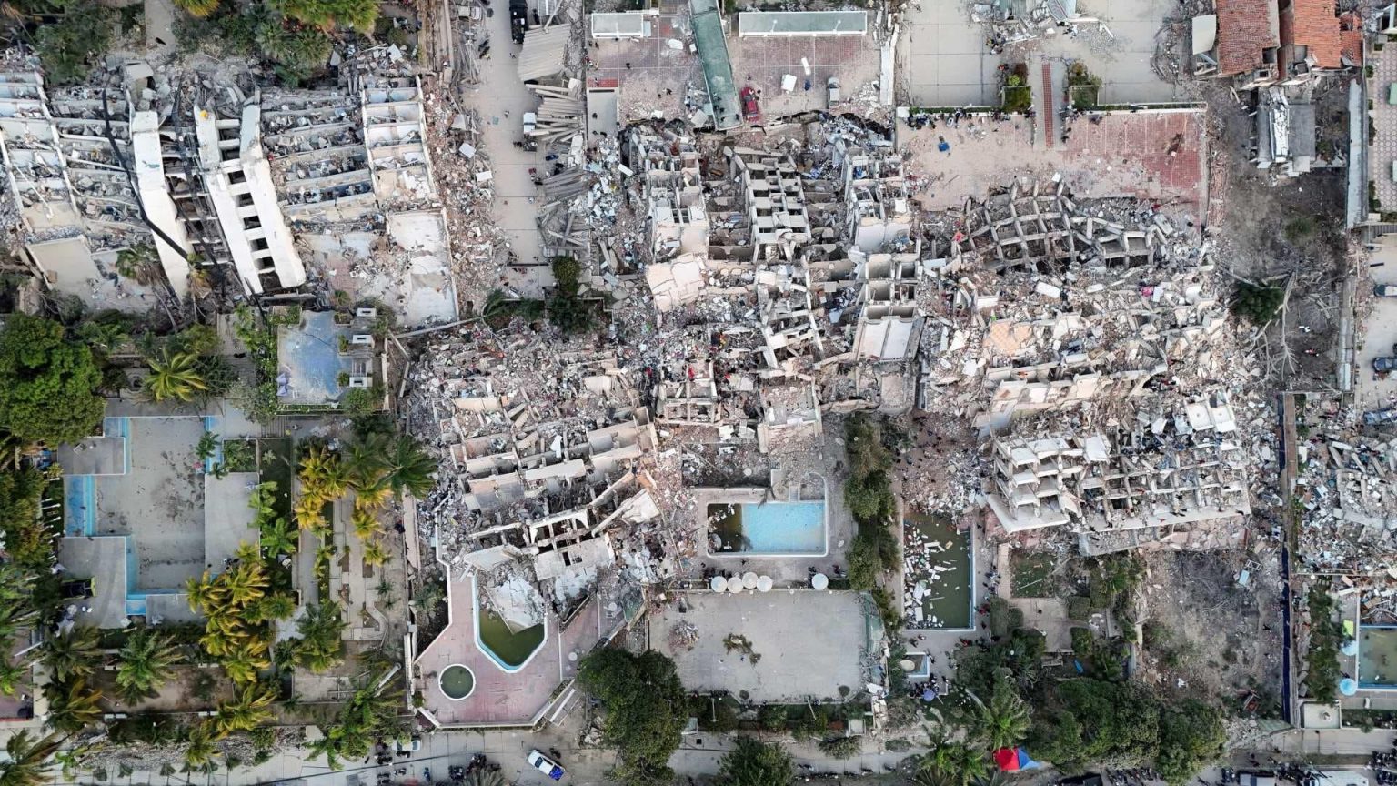 Teen Venezuela quake survivor standing near earthquake-damaged buildings in Venezuela