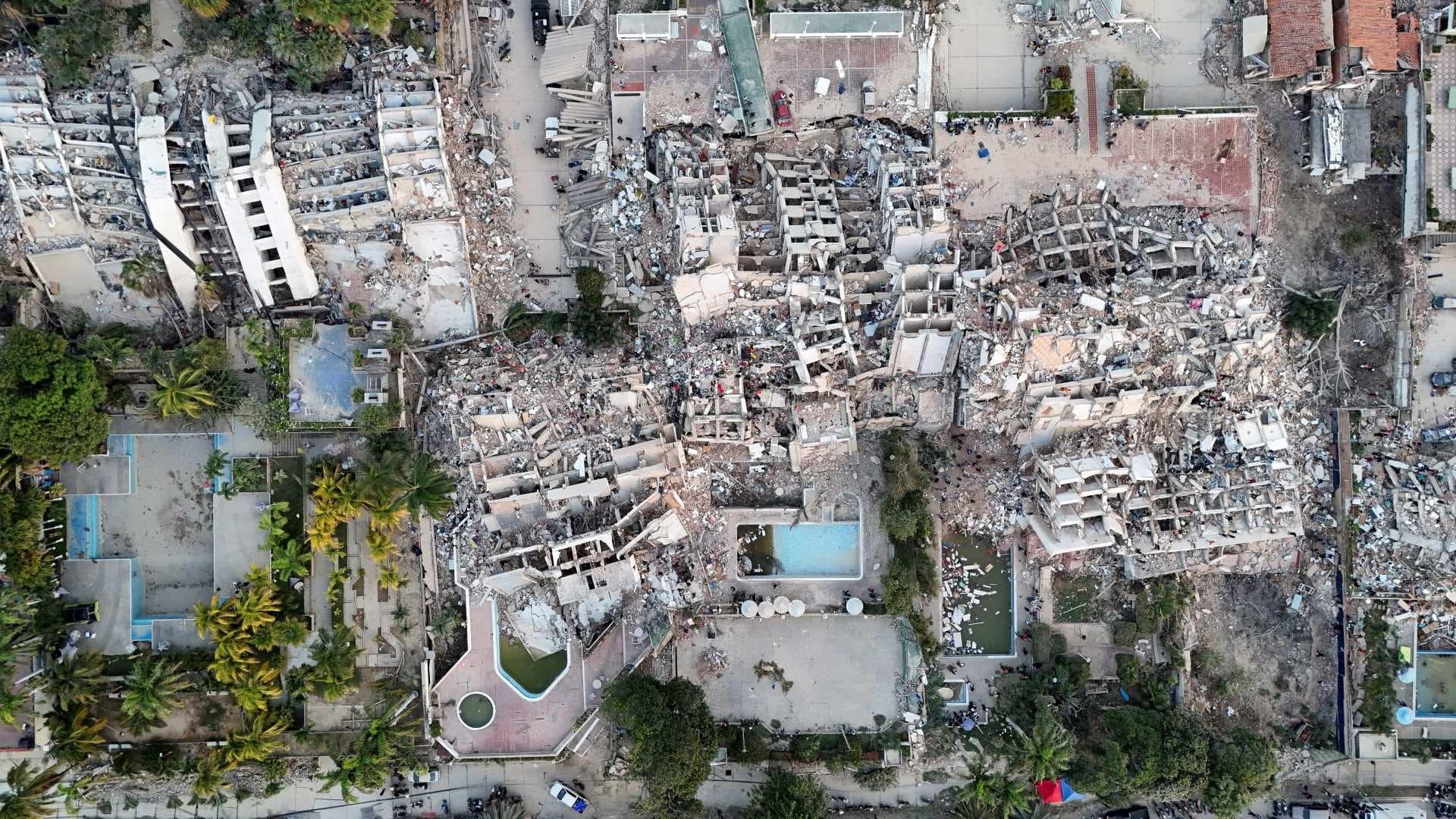 Teen Venezuela quake survivor standing near earthquake-damaged buildings in Venezuela