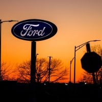 Technician inspecting vehicle wiring during automotive defect news recall process